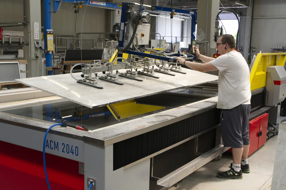 Operator neemt een gesneden plaat van de ACM 2040 met een hefbalk.