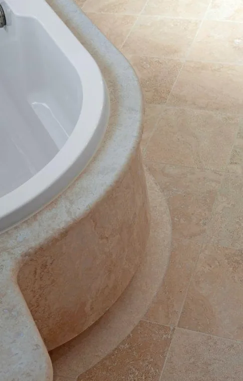 Natural stone surrounding a built-in bathtub.